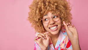 <a href="https://www.freepik.com/free-photo/close-up-shot-curly-haired-woman-uss-dental-floss-takes-care-oral-hygiene-looks-away-wears-transparent-eyeglasses-poses-against-pink-background-copy-space-your-promotional-content_26957621.htm">Image by wayhomestudio</a> on Freepik